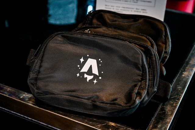 A black belt bag branded with the Astro Together logo in white.