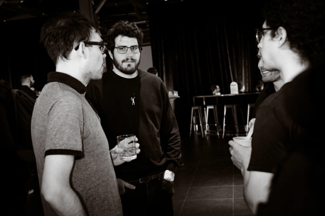 Black and white photo of a group of guests talking to each other.