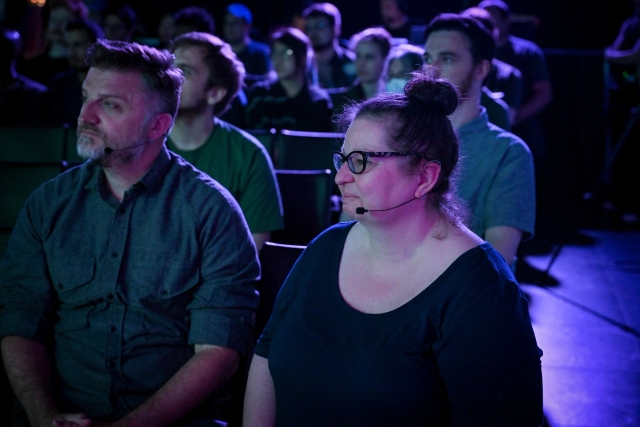 A shot of Sarah, another keynote speaker, in the front row watching Ben Holmes speak on stage.