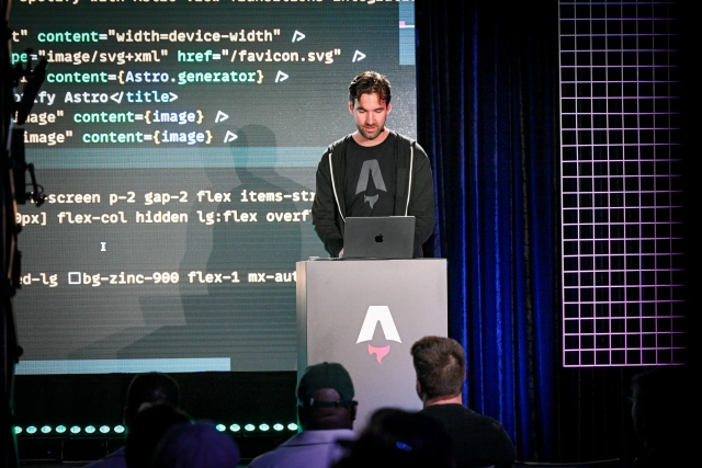 Fred K. Schott behind an Astro-branded podium as he does a live demo. On-screen is a code example.