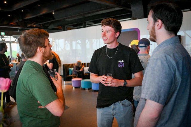 A couple guests chatting while holding drinks.