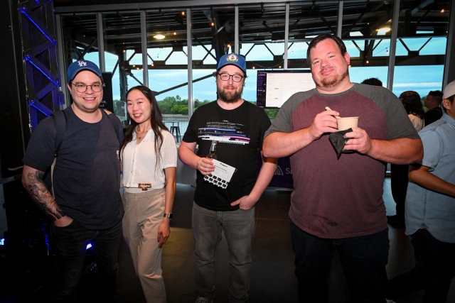 Guests post for a group photo while holding their food and drink.