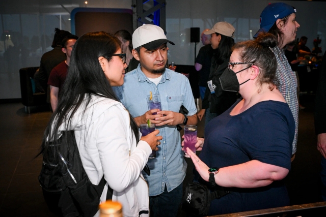 Sarah Rainsberger, wearing a black mask, chatting with guests.