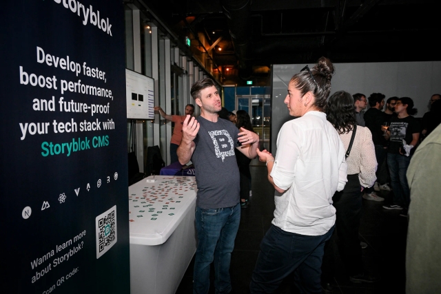 Storyblok explaining their product to a guest at their sponsor booth.